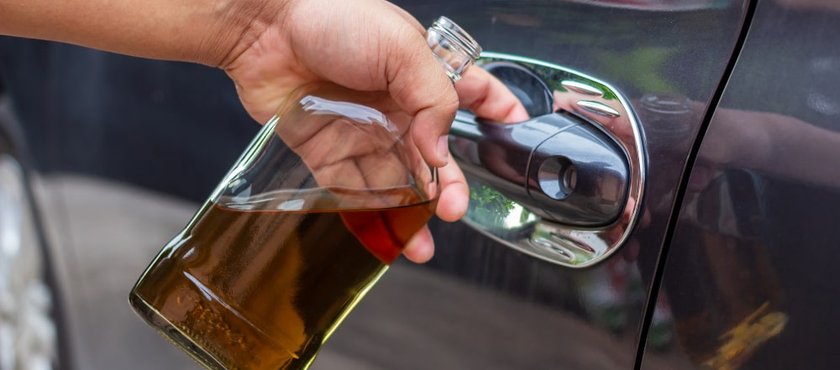drunk-driver-holding-whiskey-bottle