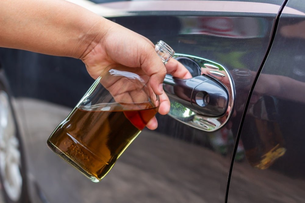 drunk-driver-holding-whiskey-bottle