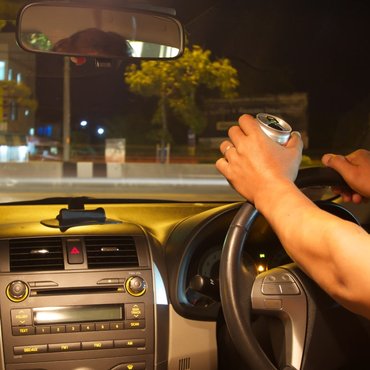 young-man-driving-with-open-beer-can