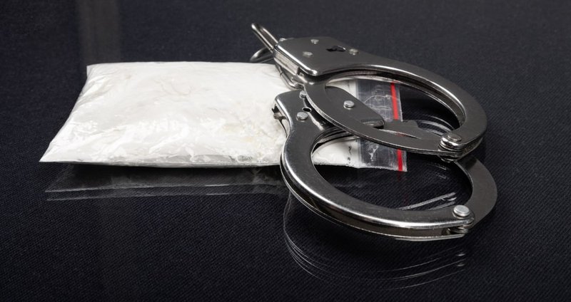 A police officer detaining a suspect during a drug trafficking investigation in Canada