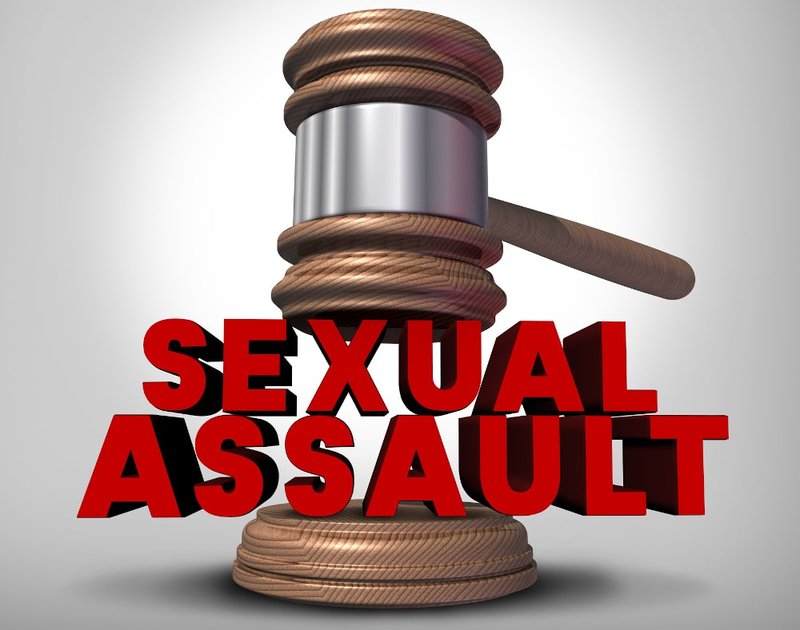 Scales of justice beside the Canadian Criminal Code, representing legal handling of sexual assault.