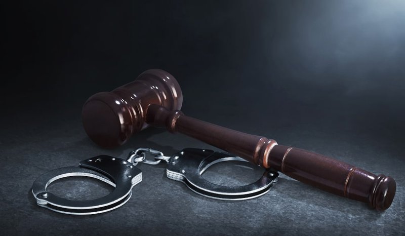 Judge’s gavel and handcuffs symbolizing legal consequences of criminal conspiracy charges