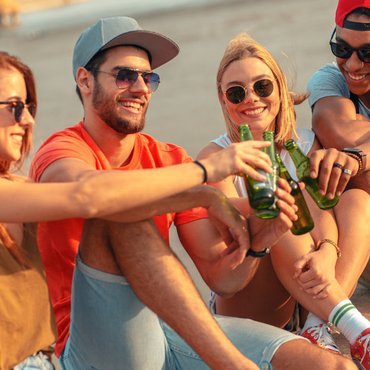 Group of friends drinking alcohol in a city setting, illustrating how public drinking laws in Canada vary under federal, provincial, and municipal rules.
