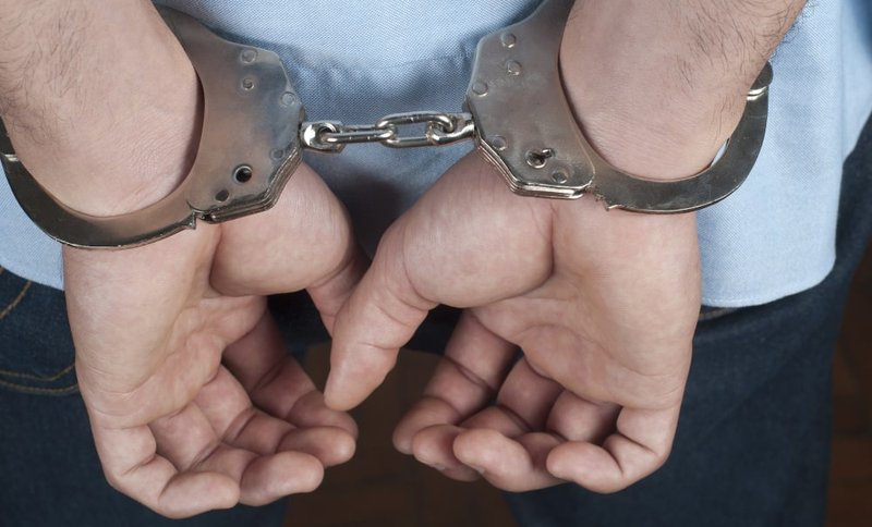 Person being escorted to a detention cell following a DUI arrest in Ontario