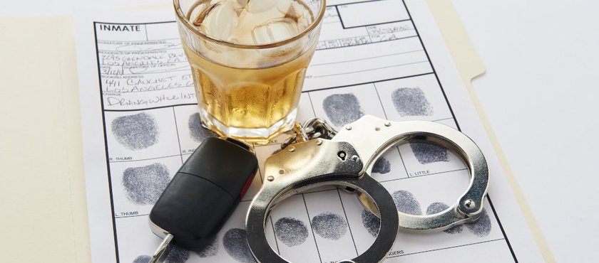 Conceptual image showing handcuffs, car keys, and alcohol, illustrating how DUI charges may affect employment and legal status in Ontario.