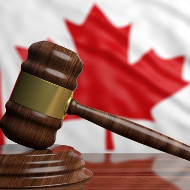 Judge’s gavel on a Canadian flag background representing the entrapment defence in Canadian criminal law