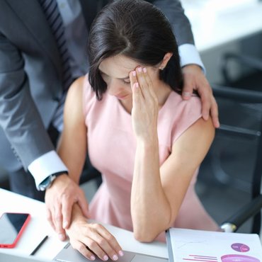 businessman-pestering-female-colleague-workplace