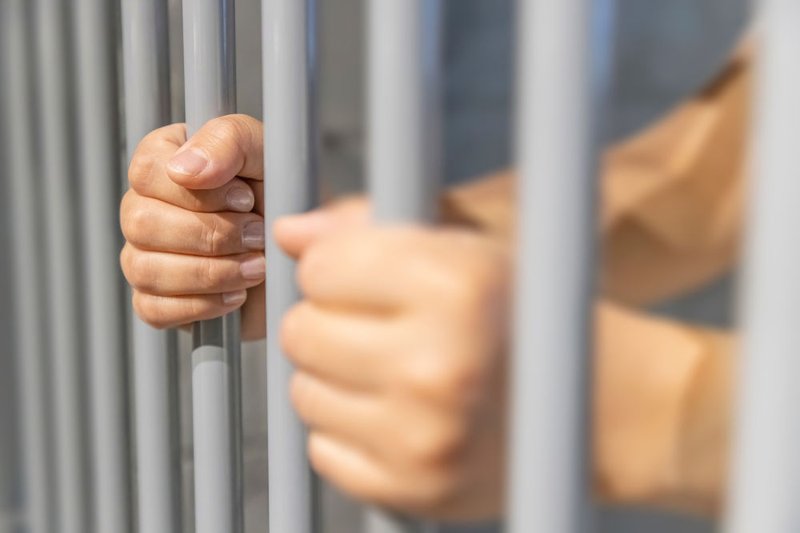 Incarcerated individual behind bars representing offenders serving life sentences who may become eligible for parole but remain under supervision for life.
