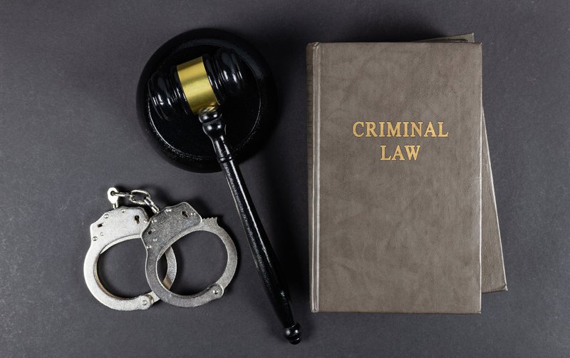 Handcuffs and a judge’s gavel illustrating police conduct and abuse of process issues in entrapment cases