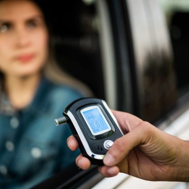 traffic-cop-holding-breathalyzer