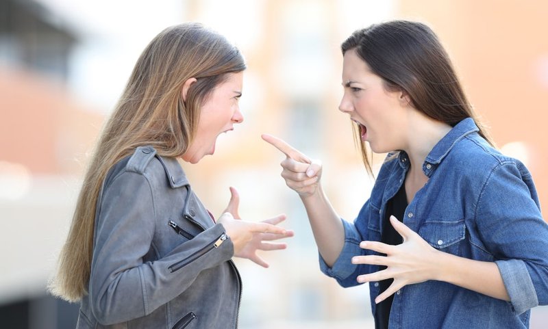 Two women yelling during a heated domestic argument, representing situations where uttering threats may result in criminal charges