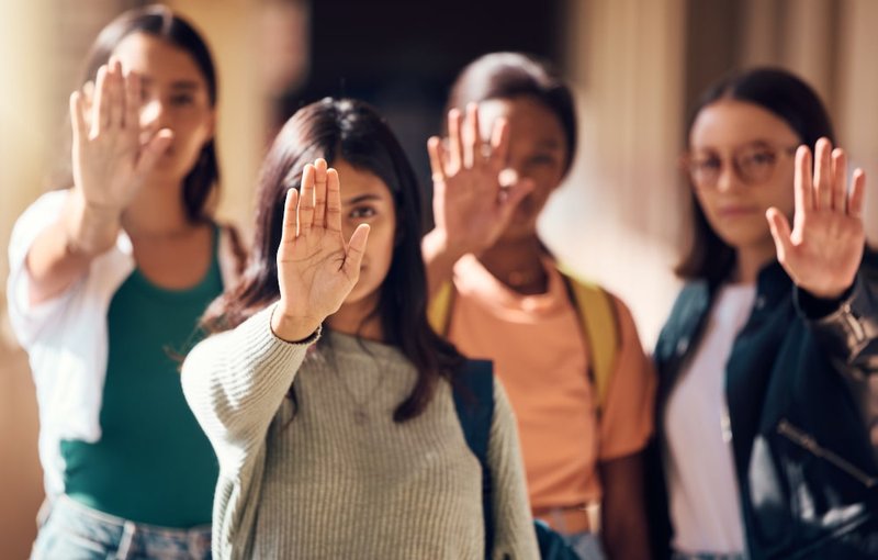 Young person raising a hand in a protective gesture representing Canadian age of consent protections